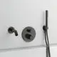 Klinkenarmatur von Ideal Standard mit zwei Bedienelementen und Handbrause. In mattschwarz, für Wandmontage, an heller Wand positioniert.